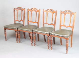 A set of 4 Edwardian carved walnut dining chairs with arched backs and bobbin turned decoration, over stuffed seats, raised on turned supports 