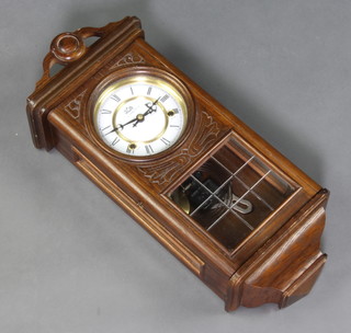 The Time MFG Co, a striking wall clock with enamelled dial with Roman numerals contained in an oak case 