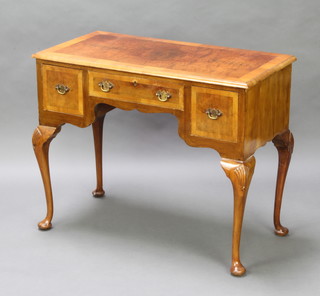 A Queen Anne style crossbanded and figured walnut side table, fitted a 3 drawers, raised on cabriole supports 76cm h x 94cm w x 47cm d  