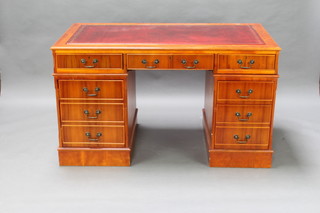 A yew finished desk with red inset writing surface, fitted a computer drawer flanked by 2 short drawers, one pedestals enclosed by a panelled door, the other fitted 3 drawers  79cm h x 126cm w x 77cm d (hole to 1 of the pedestals) 