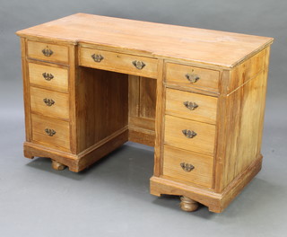 A Victorian pitched pine inverted breakfront kneehole pedestal desk fitted a drawer flanked by 8 short drawers, raised on bun supports 78cm h x 122cm w x 57cm (this lot is in one section and does not split, there is a water mark to the top)