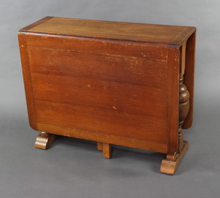 An Art Deco oak drop flap gateleg dining table raised on cup and cover supports 77cm h x 91cm w x 35cm 