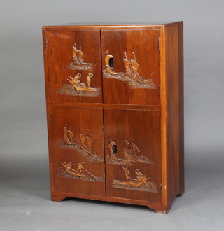 A 1950's Chinese carved hardwood cabinet enclosed by panelled doors, decorated junks and figures 99cm h x 68cm w x 35cm d
