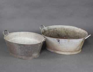 An oval galvanised metal 2 handled bath 28cm h x 84cm l x 61cm w and 1 other 26cm h x 62cm l x 47cm w 