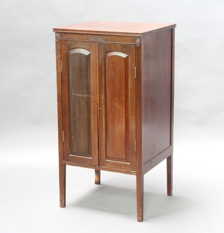 An Edwardian carved mahogany music cabinet the shelved interior enclosed by arched panelled doors 91cm h x 47cm w x 41cm d 