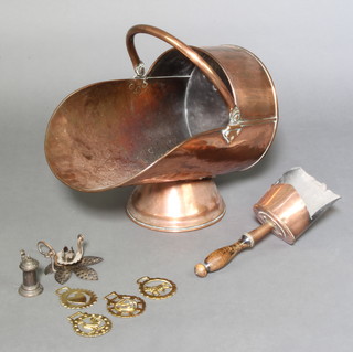 A 19th Century copper helmet shaped coal scuttle with shovel and a collection of horse brasses 
