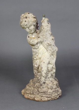 A concrete garden fountain in the form of a cherub with a fish 60cm h x 28cm diam