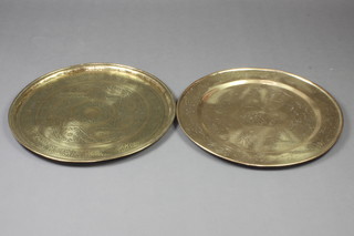 A Chinese heavy gauge circular engraved brass charger decorated a dragon 46cm and an Eastern ditto 48cm diam. 
