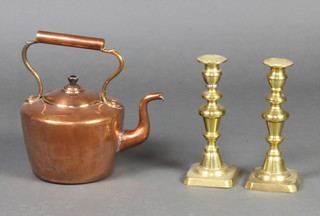 A Victorian copper kettle 35cm and a pair of Victorian brass candlesticks with ejectors 22cm 