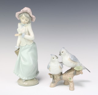 A Lladro group of 2 birds on a stump 10cm, a Nao figure of a girl with a dove 15cm (both a/f)
