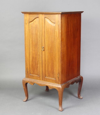 An Edwardian mahogany music cabinet with shelved interior enclosed by panelled doors 103cm h x 52cm w x 46cm d