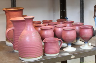 A quantity of Stephen Llewellyn pottery comprising 2 jugs, a carafe and 11 goblets