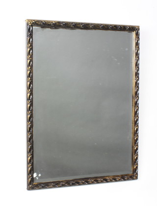 A rectangular bevelled plate wall mirror contained in a decorative gilt frame 63cm x 47cm and an oval plate mirror contained in an oak frame 39cm x 77cm 
