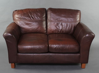 A 2 seat sofa upholstered in brown leather 80cm h x 139cm w (seat is showing signs of wear) 
