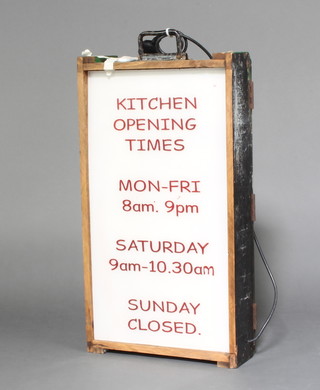 A pine and perspex rectangular sign marked Kitchen opening times Monday - Friday 8am-9pm, Saturday 9.am-10.30am, Closed on Sunday 78cm h x 40cm x 13cm  
