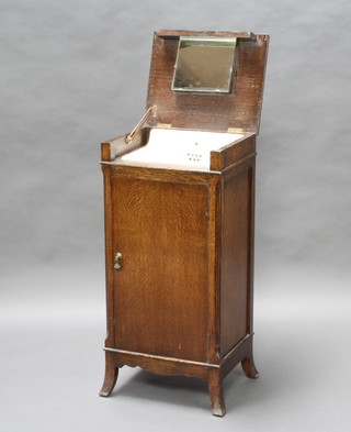 A 1920's enclosed wash stand incorporating a porcelain sink and contained in an oak cabinet with hinged lid above a panelled door 90cm h x 41cm w x 34cm d (some water damage to the top) together with a bedroom chair with cane seat 