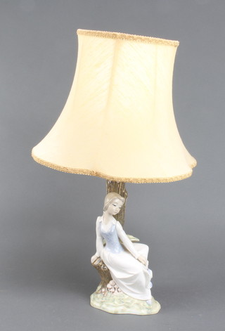 A Spanish pottery table lamp in the form of a seated girl beneath a tree 30cm x 16cm x 12cm 