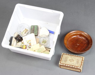 A turned wooden bowl together with a collection of various cigarette cards