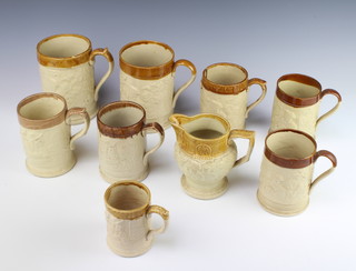 A Victorian stoneware moulded mug with revelling scene, 7 others and a ditto jug (3 mugs and the jug are cracked)
 
