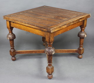 A 1930's oak draw leaf dining table raised on cup and cover supports with X framed stretcher 73cm x 90cm x 92cm (some water marks) 