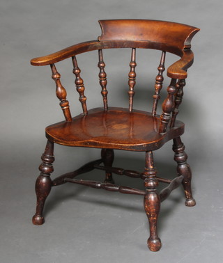 An elm smokers bow chair with solid seat, raised on turned supports with H framed stretcher 