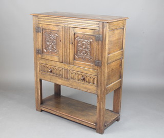 An Ipswich style carved oak hutch cabinet, the upper section enclosed by panelled doors above 2 long drawers with arcaded decoration and undertier 107cm h x 91cm w x 38cm d 