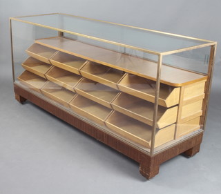 An Art Deco gilt 'bronze" and oak "drapers display cabinet", fitted shelves above 12 drawers 87cm h x 183cm w x 61cm d  