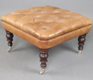 A Victorian style rectangular mahogany stool, the seat upholstered in light brown buttoned leather, raised on turned supports with chrome caps and casters 45cm x 77cm x 77cm 