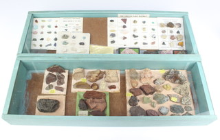 Two shallow display cabinets containing a collection of geological specimens 