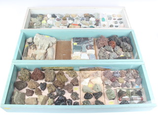 Three shallow display cabinets containing geological specimens 