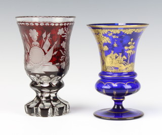 A 19th Century Bohemian red flash glass vase decorated with military motifs and flowers 15cm together with a blue glass gilt decorated vase showing a hunting scene 14cm 