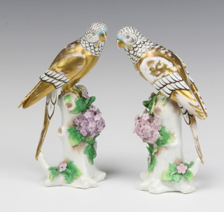 A pair of Sampson figures of budgerigars sitting on floral encrusted tree stumps 17cm  