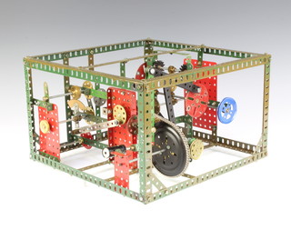 A Meccano working model with cogs, etc 21cm x 32cm x 32cm 