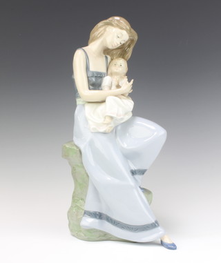A Nao figure of a lady holding a young girl seated on a rocky outcrop no.1297, 37cm 