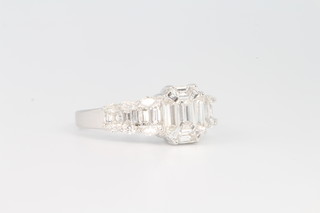An 18ct white gold emerald baguette and marquise cut diamond ring, total weight approx. 1.35ct, size 0 1/2