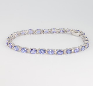 An 18ct white gold tanzanite and diamond line bracelet, tanzanites 9.22ct, diamonds 0.65ct 17.5cm 