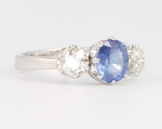 An 18ct white gold sapphire and diamond ring, the centre oval stone flanked by brilliant cut diamonds approx. 0.6ct size N 