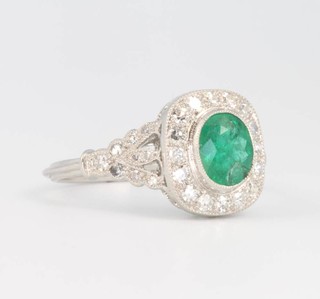 A platinum Edwardian style emerald and diamond cluster ring, the emerald approx. 1ct surrounded by brilliant cut diamonds size O 