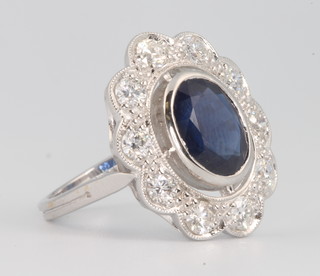 An 18ct white gold oval and sapphire diamond ring, the centre oval stone approx. 3.31ct surrounded by brilliant cut diamonds 1.12ct, size N 