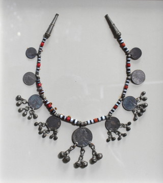 An Eastern coral and bone necklace set 9 coins and bells framed