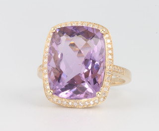 A 14ct yellow gold cushion cut amethyst and diamond ring, the centre stone approx. 9.4ct surrounded by brilliant cut diamonds approx. 0.3ct, size M 1/2