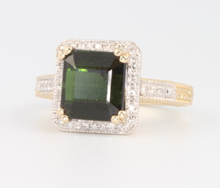 A 14ct yellow gold emerald cut tourmaline and diamond ring, the centre stone approx. 4.1ct surrounded by brilliant cut diamonds approx. 0.25ct, size L 1/2