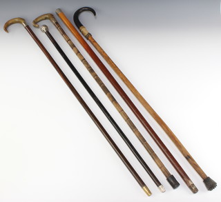 A walking cane with silver knop and 4 other walking sticks and canes