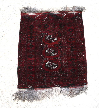 A red and black ground Afghan rug with 3 octagons to the centre within a multi row border 92cm x 75cm 
