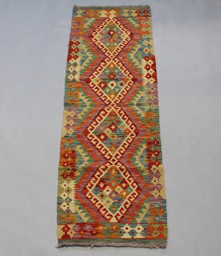 A green and yellow ground flat bed Kilim runner with 4 diamond medallions to the centre 196cm x 60cm 