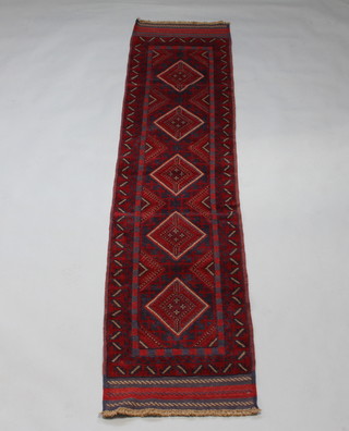 A red and blue ground Meshwani runner with 5 stylised diamonds to the centre within a multi row border 265cm x 62cm 