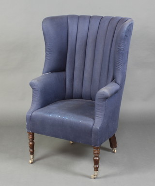 A Georgian style tub back armchair upholstered in blue material and raised on turned supports ending chromed caps and casters 