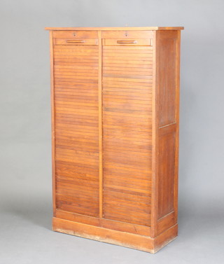 A 1930's Art Deco light oak filing cabinet, fitted trays enclosed by tambour shutter, raised on a platform base 149cm h x 89cm w x 38cm d 