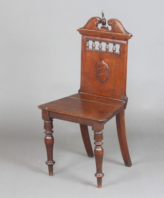 A Victorian mahogany hall chair with bobbin turned decoration, shield back and solid seat, raised on turned supports 