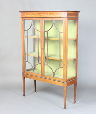 An Edwardian inlaid mahogany display cabinet, fitted shelves enclosed by astragal glazed panelled doors, raised on square tapered supports ending in brass caps and casters 161cm h x  104cm w x 37cm 